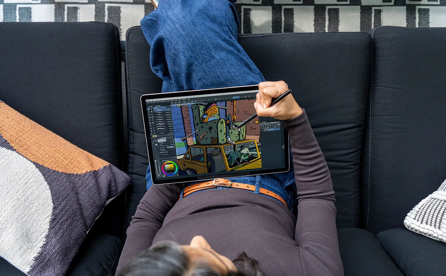 Photographer using stylus on iPad displaying colorful digital artwork with architectural floor plan overlay