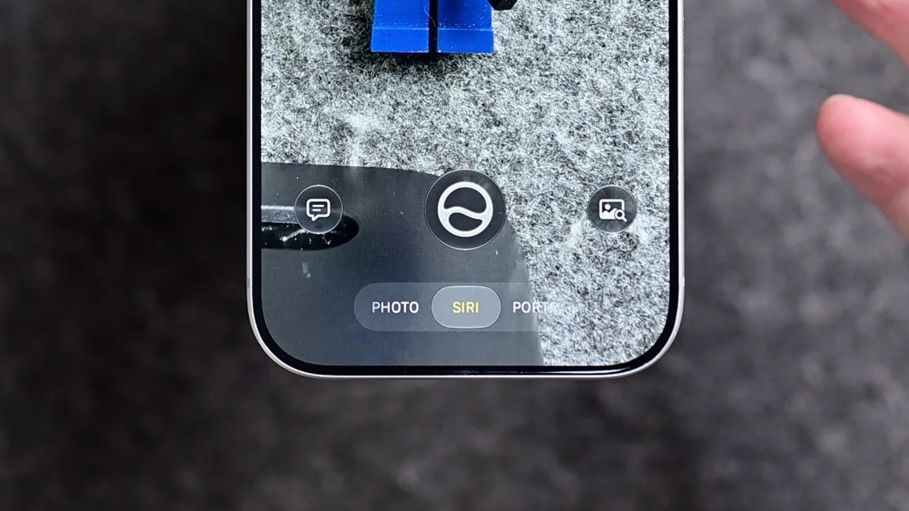 Close-up of a smartphone screen using camera app in Siri mode, focusing on blue toy legs on a gray surface, with a hand visible on the right edge