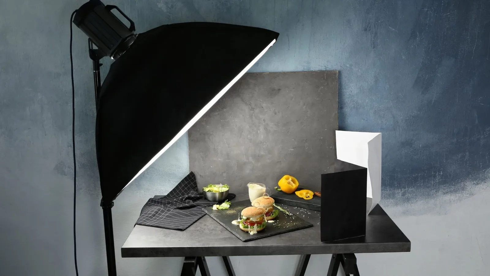 A food photography scene with a beautifully lit setup, showcasing fresh vegetables and ingredients, and professional lighting equipment.