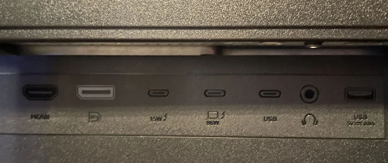 A panel with HDMI, DisplayPort, multiple USB-C, headphone, and USB ports labeled with power specifications and symbols.