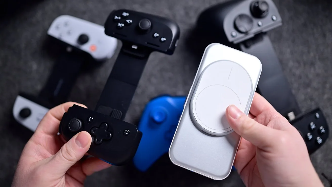 Hands holding a smartphone gaming controller and circular device, with other controllers nearby on a gray surface.