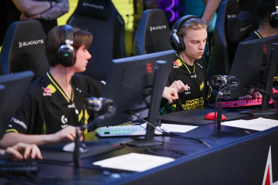 CS2 pro players from the team NAVI, fist-bumping a match at the esports tournament StarSeries Season 20 — a photo.