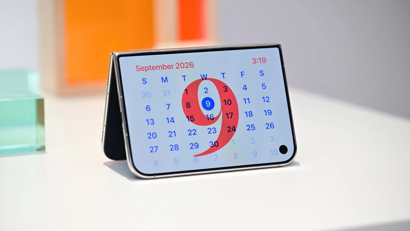 Folded smartphone on a table displaying a September 2026 calendar, with the 10th highlighted by a large red number nine-shaped circle, against a minimal, colorful background