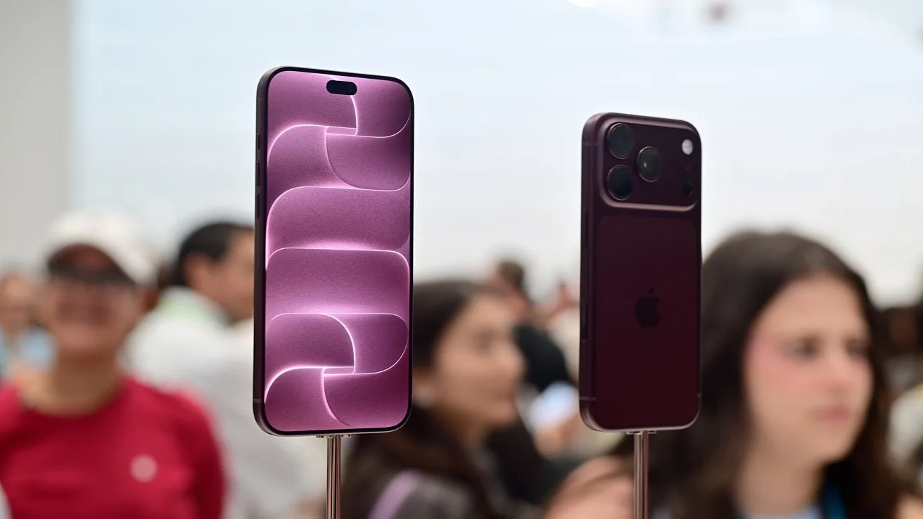 Two purple smartphones on stands, one showing a lit abstract screen and the other showing the back with cameras, surrounded by slightly blurred people at a tech event