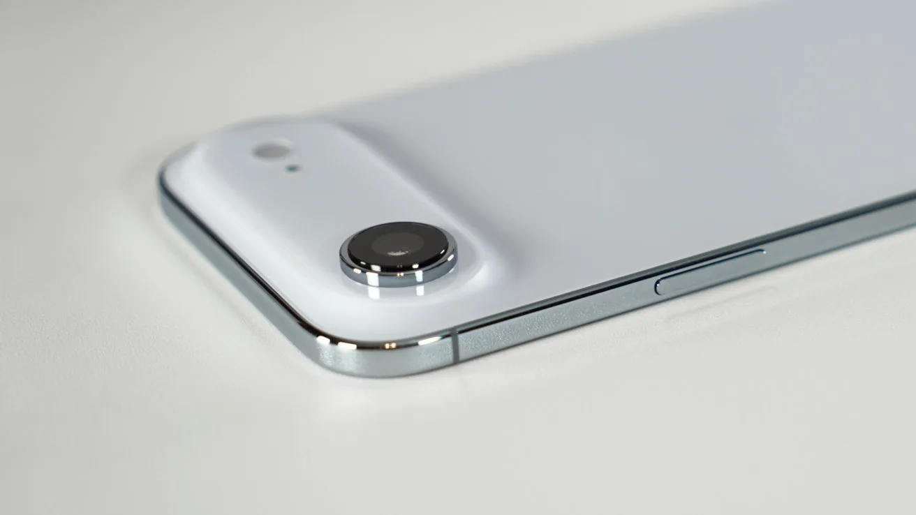 Close-up of a modern white smartphone lying flat, showing a single rear camera with raised lens, small flash, and shiny metallic edge with a side button visible