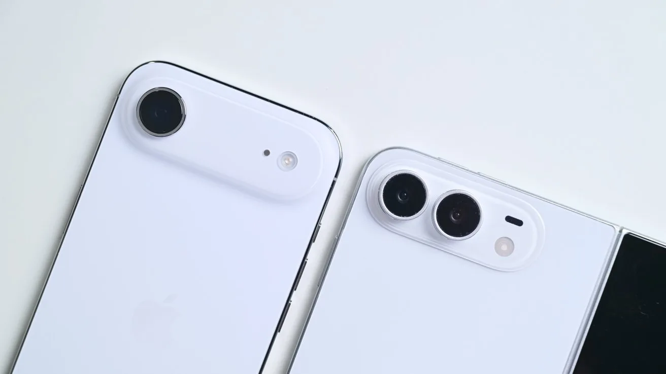 Two white smartphones on a light surface, one with a single rear camera lens, the other with two lenses and a flash, partially showing a black screen edge