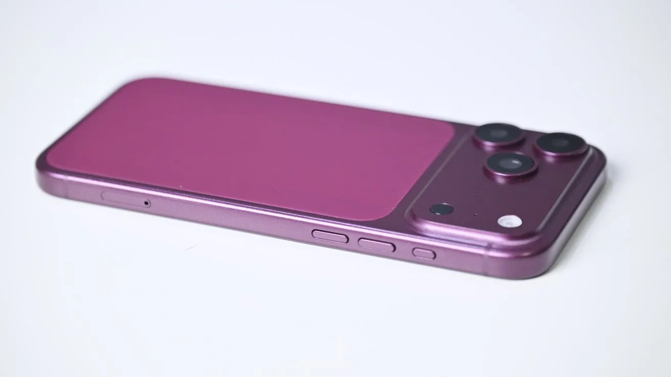 Purple smartphone lying face down, showing a dual camera bump with flash in the top corner, smooth matte back, and side buttons visible against a plain light background