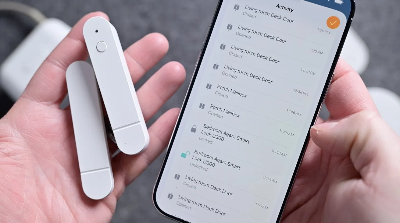 Hands holding a smartphone and two slim white smart home sensors, with the phone screen displaying a list of security activity alerts and device statuses