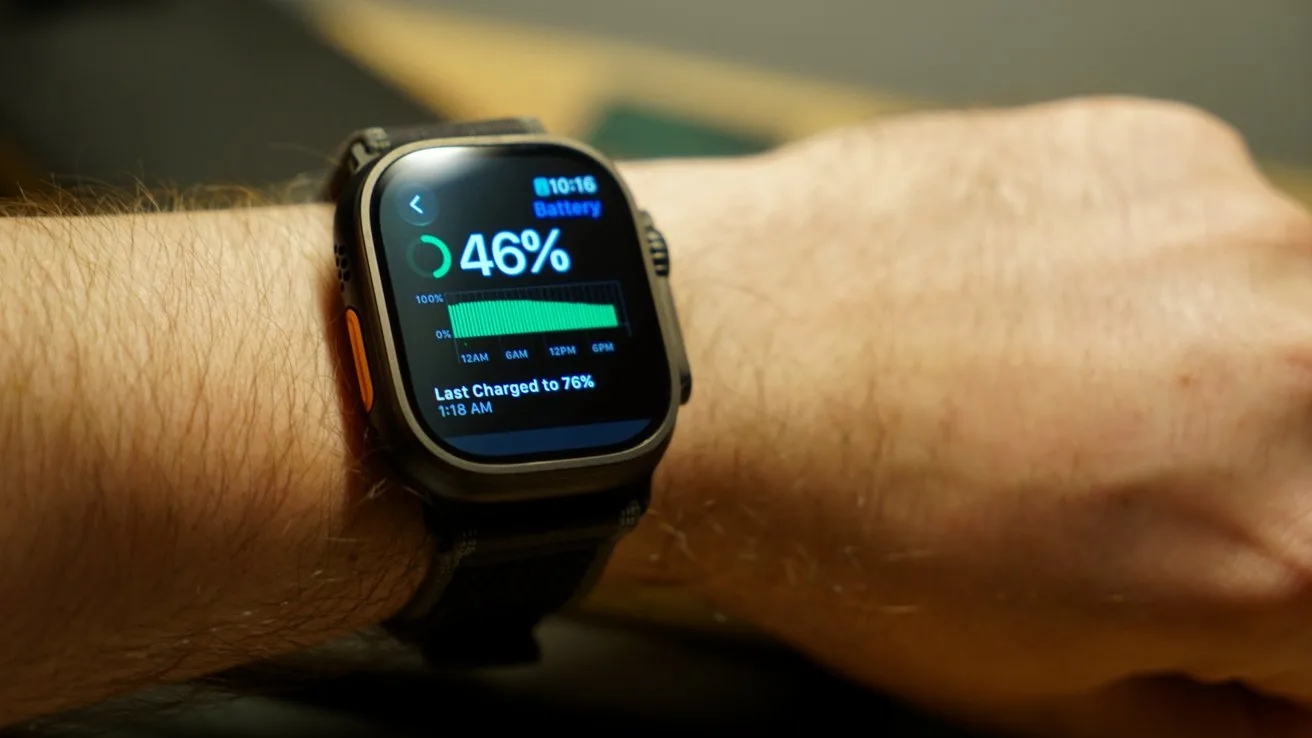 Apple Watch Ultra 4 on a person's wrist displaying battery status at 46 percent with a green progress bar and charging details on a dark screen in a softly lit indoor setting