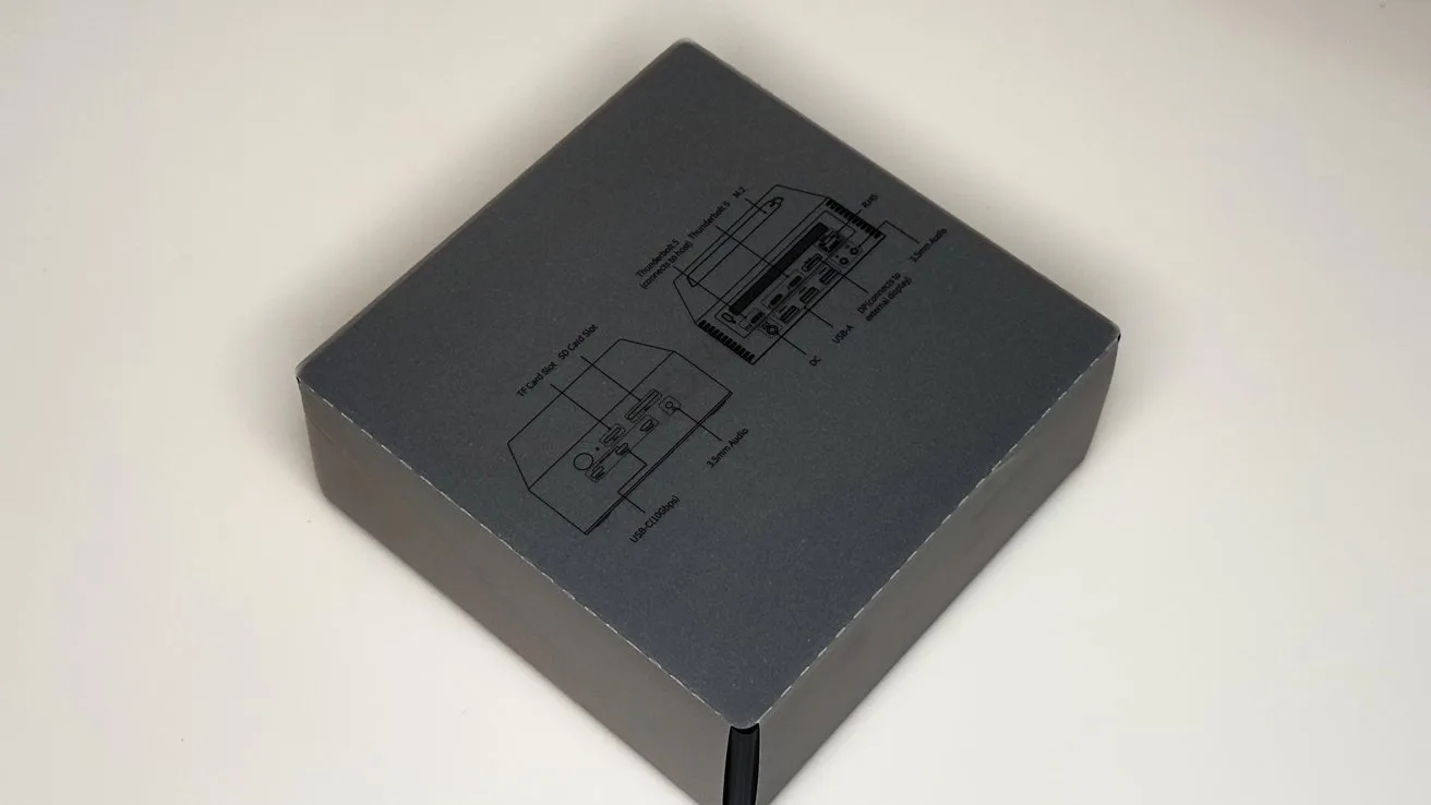 Dark gray rectangular box on a light background, with simple black line diagrams and labels printed on the lid, suggesting technical or electronic product packaging