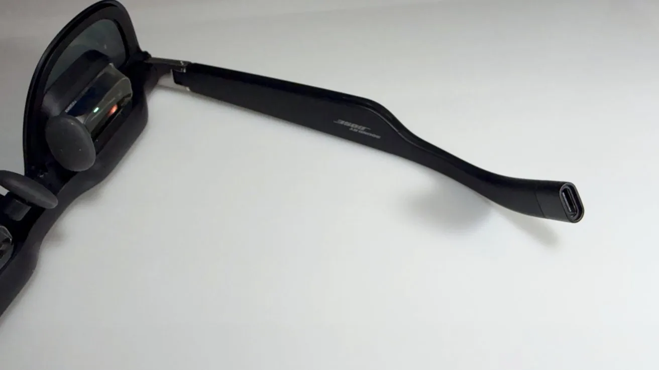 Sunglasses with sleek black frames featuring integrated technology on a clean, white background. Right arm extended towards the viewer.