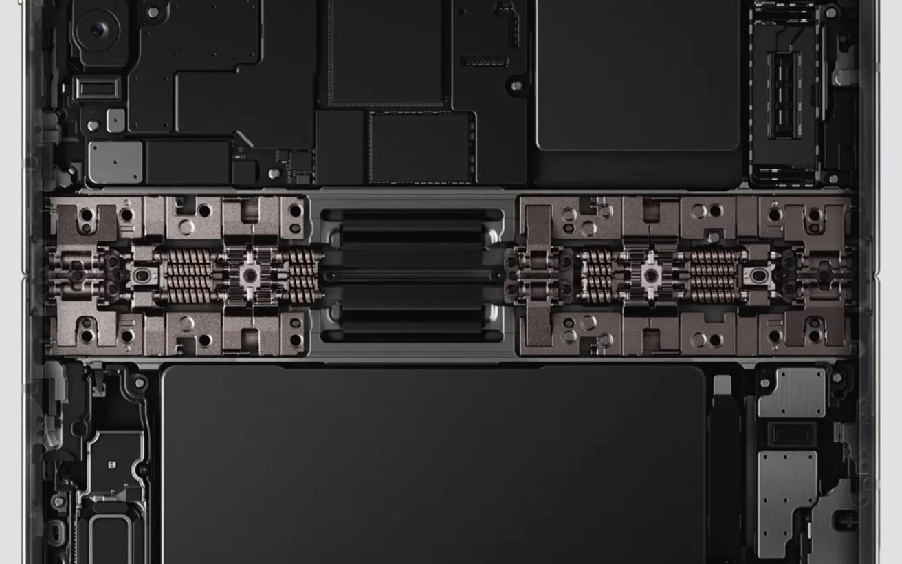 Internal view of a laptop showing symmetrical components, including a central hinge mechanism, battery cells, and circuit boards arranged in a clean, rectangular, industrial layout