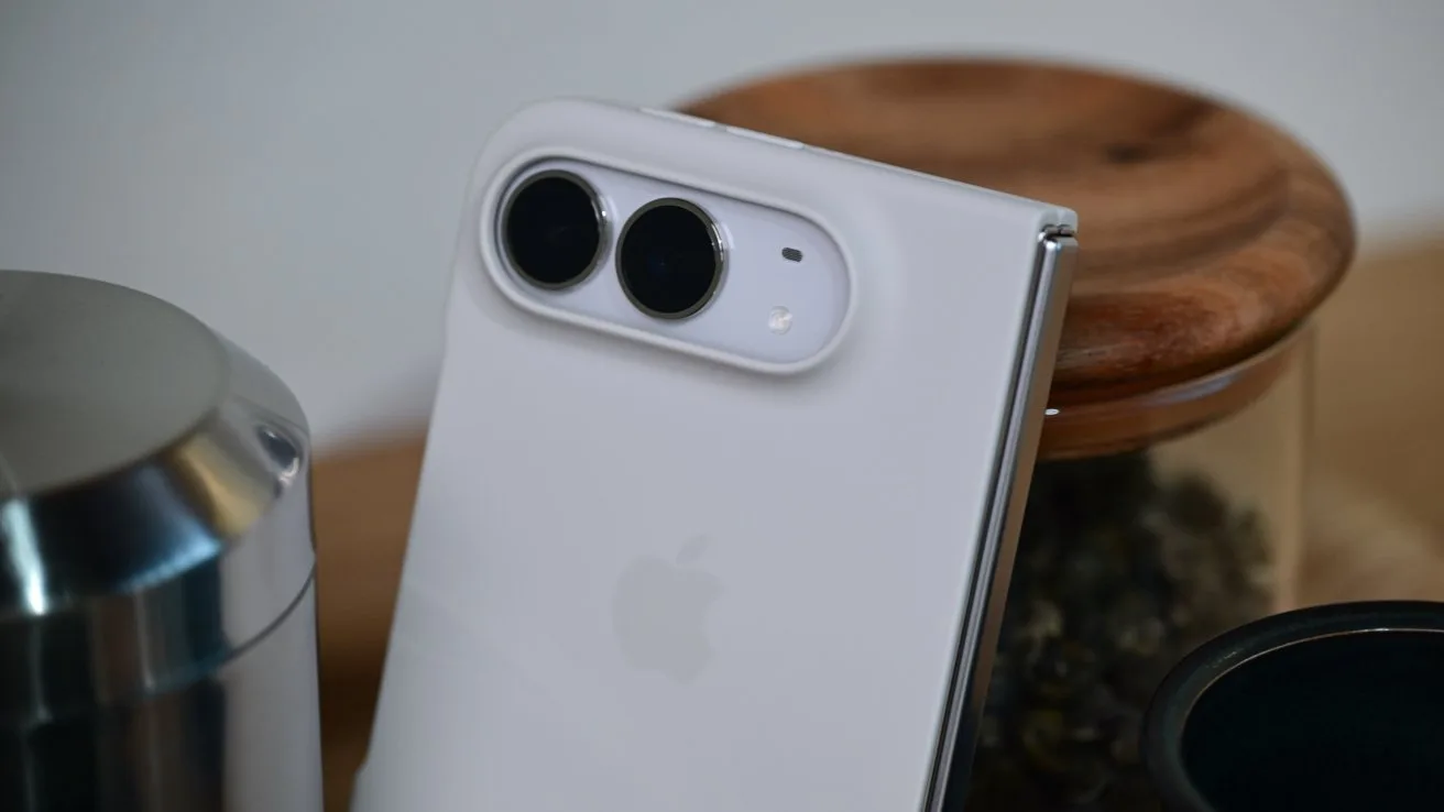 iPhone Duo closed leaning against a glass jar with a wooden lid. It has a white silicone case attached and the dual camera system is visible.