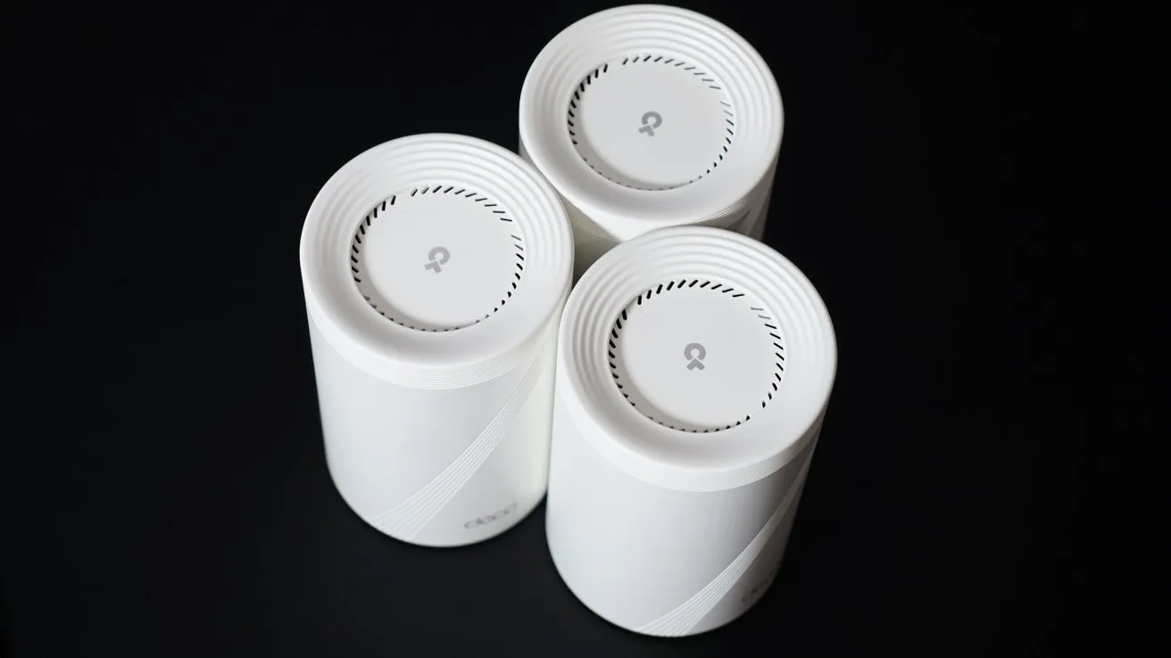 Three white cylindrical devices with a subtle leaf logo on the top, arranged in a triangular formation against a dark background.