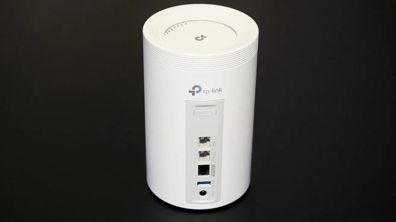 White cylindrical TP-Link router with multiple connection ports, including Ethernet and USB, on a black background.
