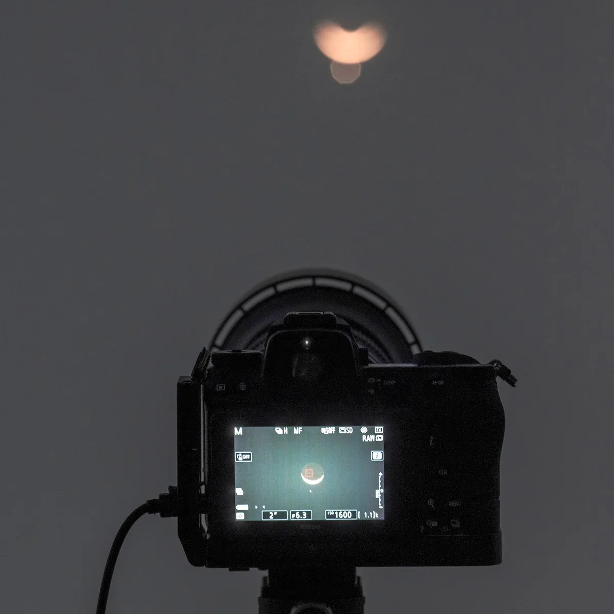Use a telephoto lens or a telescope to photograph the event