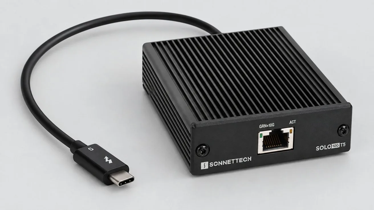 Small black SonnetTech Solo3 device with ribbed casing, single Ethernet port on the front, and a short attached Thunderbolt USB-C cable, all resting on a light gray surface