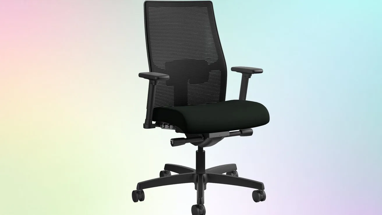Black ergonomic office chair with mesh back, padded seat, adjustable armrests, and wheeled base, centered against a soft pastel gradient background