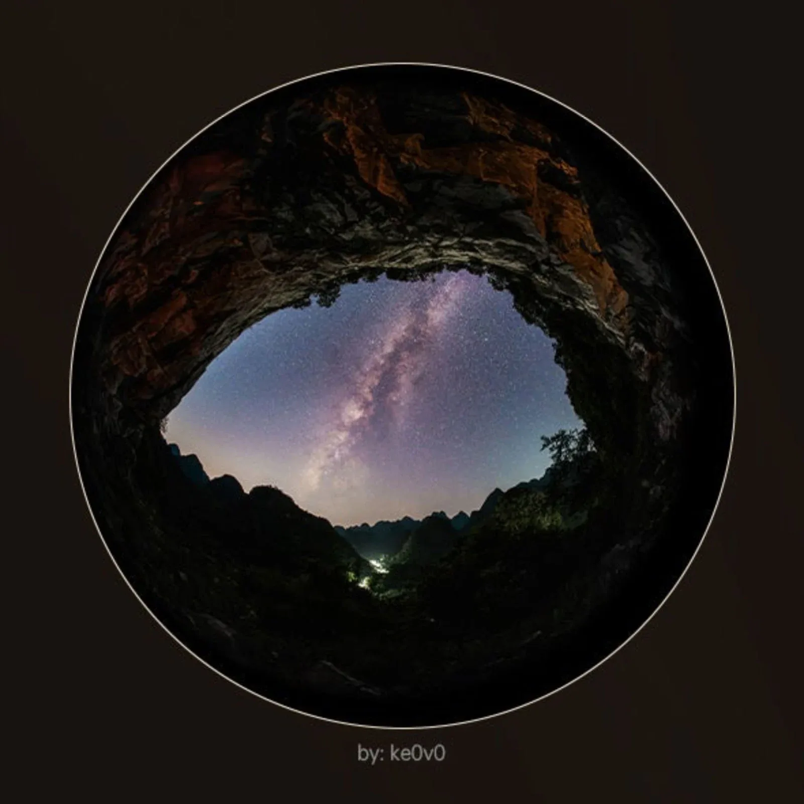 A circular fisheye view looking out from a dark cave opening toward a starry night sky with the Milky Way galaxy visible.