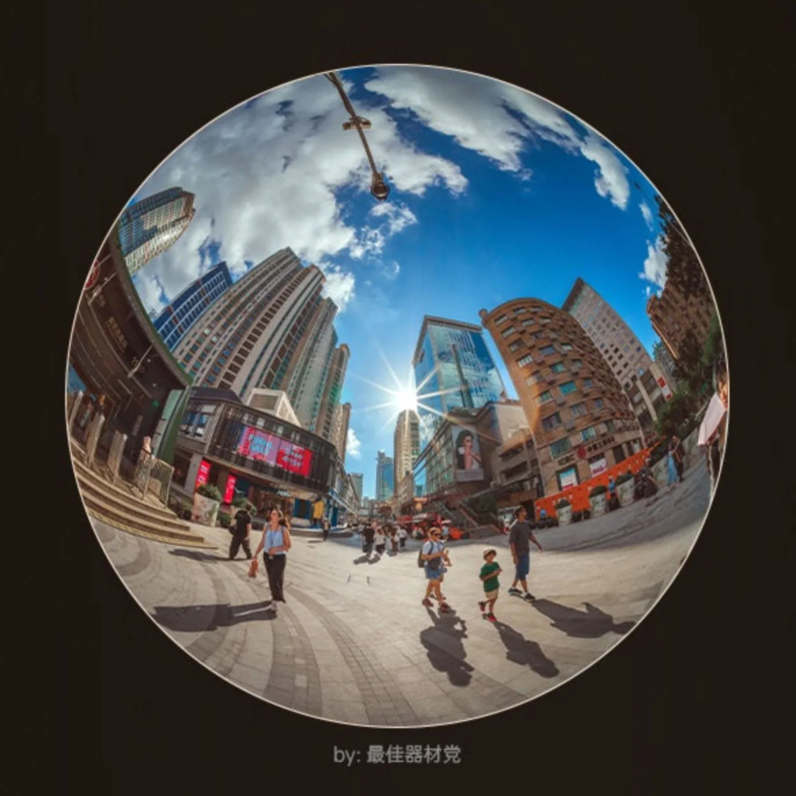 A fisheye view of a sunny city plaza with pedestrians walking among tall buildings and a bright sunburst in the sky.